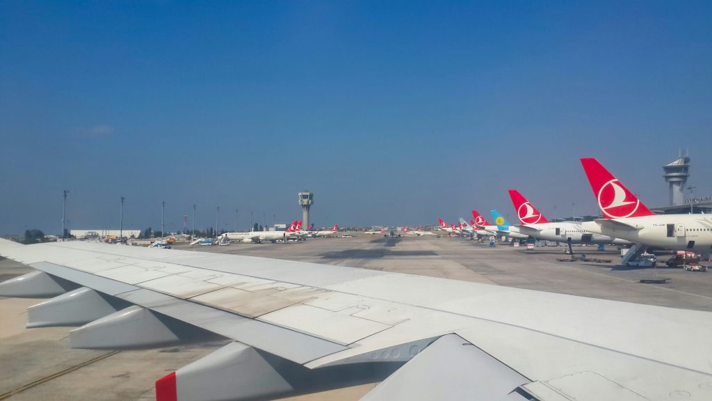 Airport runway with airplanes lined up waiting.