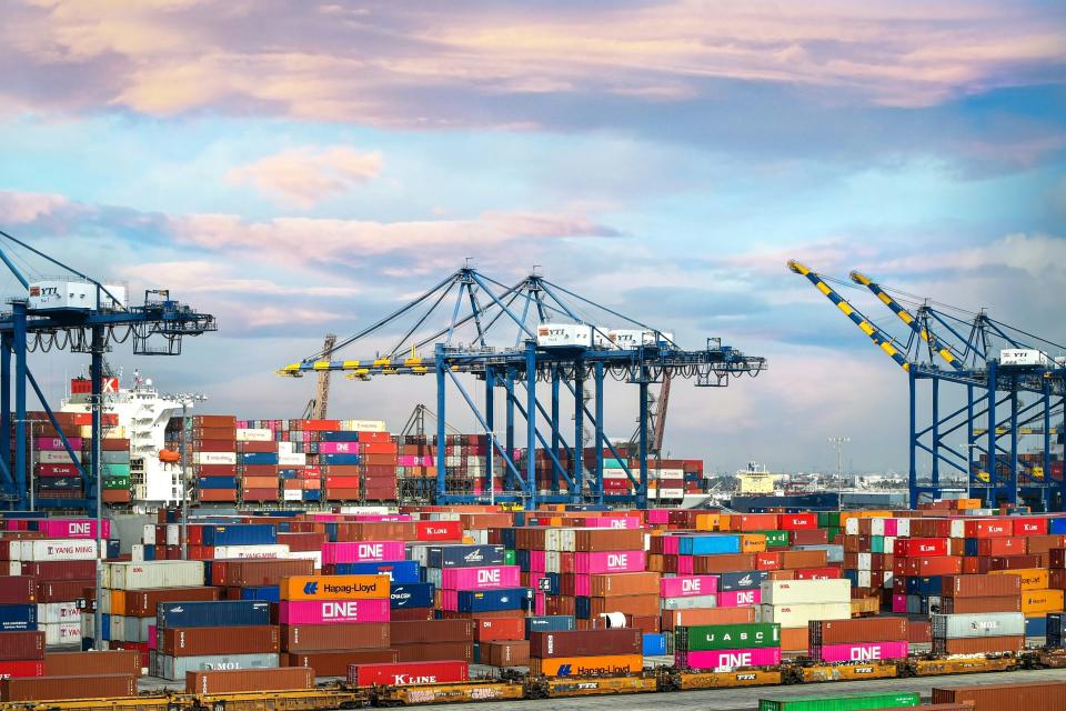 Port with cranes and multicolored cargo containers.